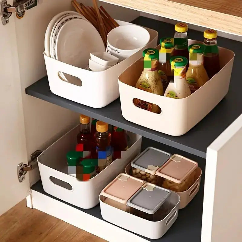 White and beige plastic storage bins holding sauces, snacks, and tableware in a kitchen cabinet