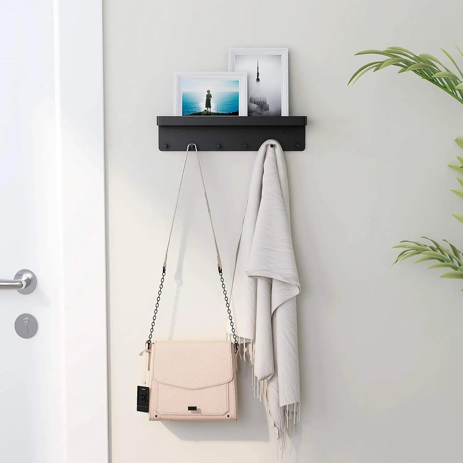 Wall-mounted black key and mail holder used near a door with purse and scarf hanging
