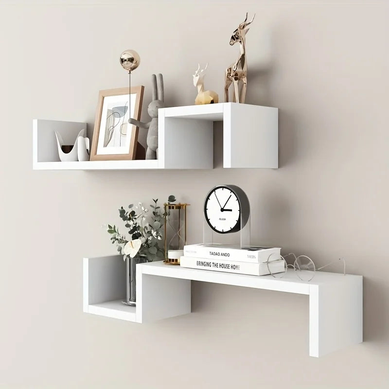 White S-shaped floating wall shelves styled with books, decor, and a clock on a beige wall