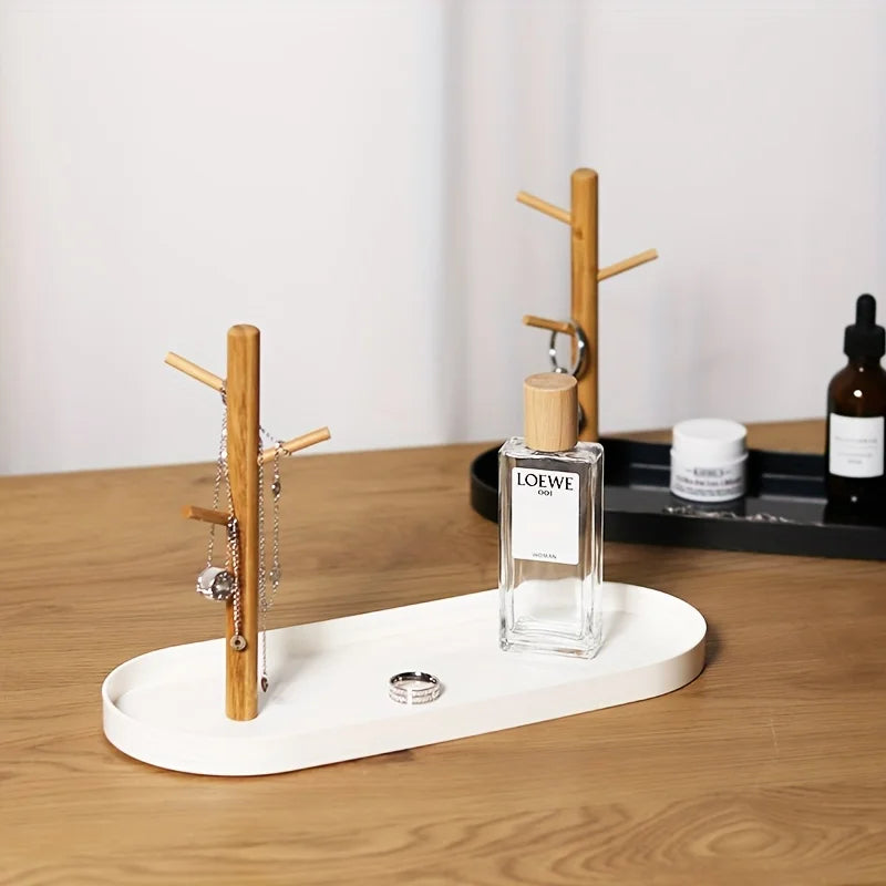 White tray with wooden jewelry tree, shown with necklace, ring, and perfume on a dresser, with black tray visible in background