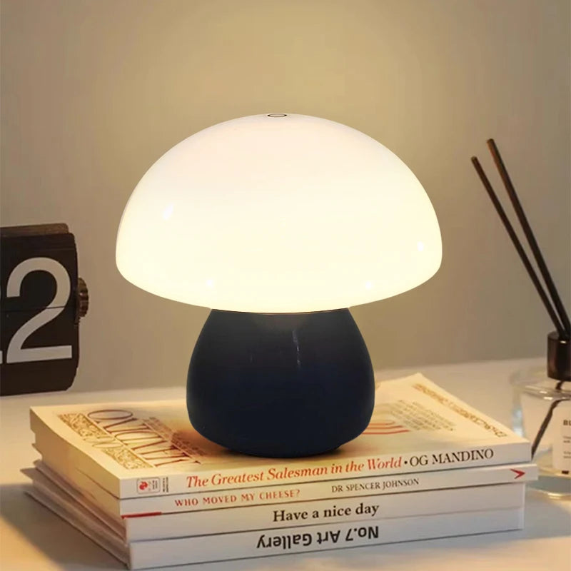 mushroom-shaped LED night light with soft glow on a stack of books