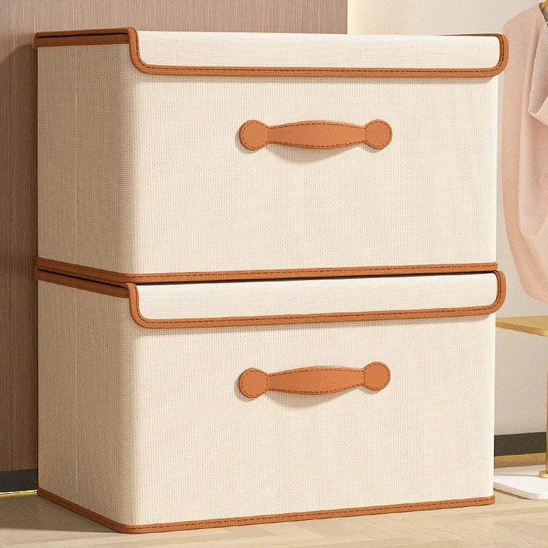 Two beige lidded storage boxes placed side by side against a wall