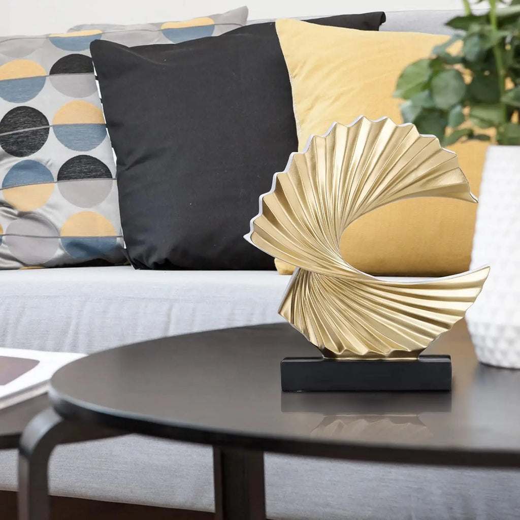 gold abstract wave sculpture on coffee table in living room with patterned pillows