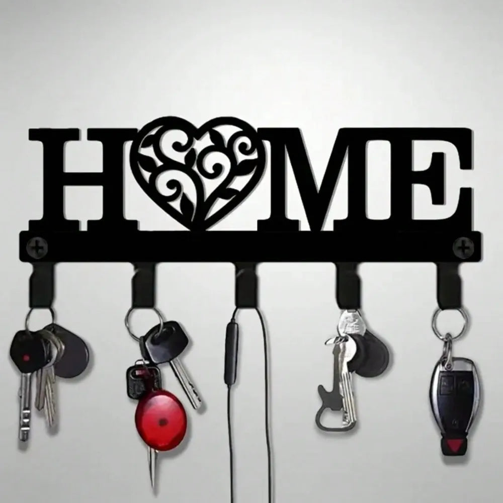 Black metal 'HOME' wall key rack with heart cutout and hooks, holding several sets of keys