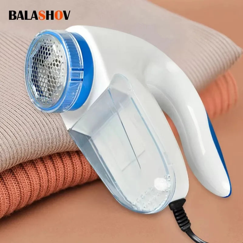 Plug-in electric lint remover in white and blue shown on folded sweaters