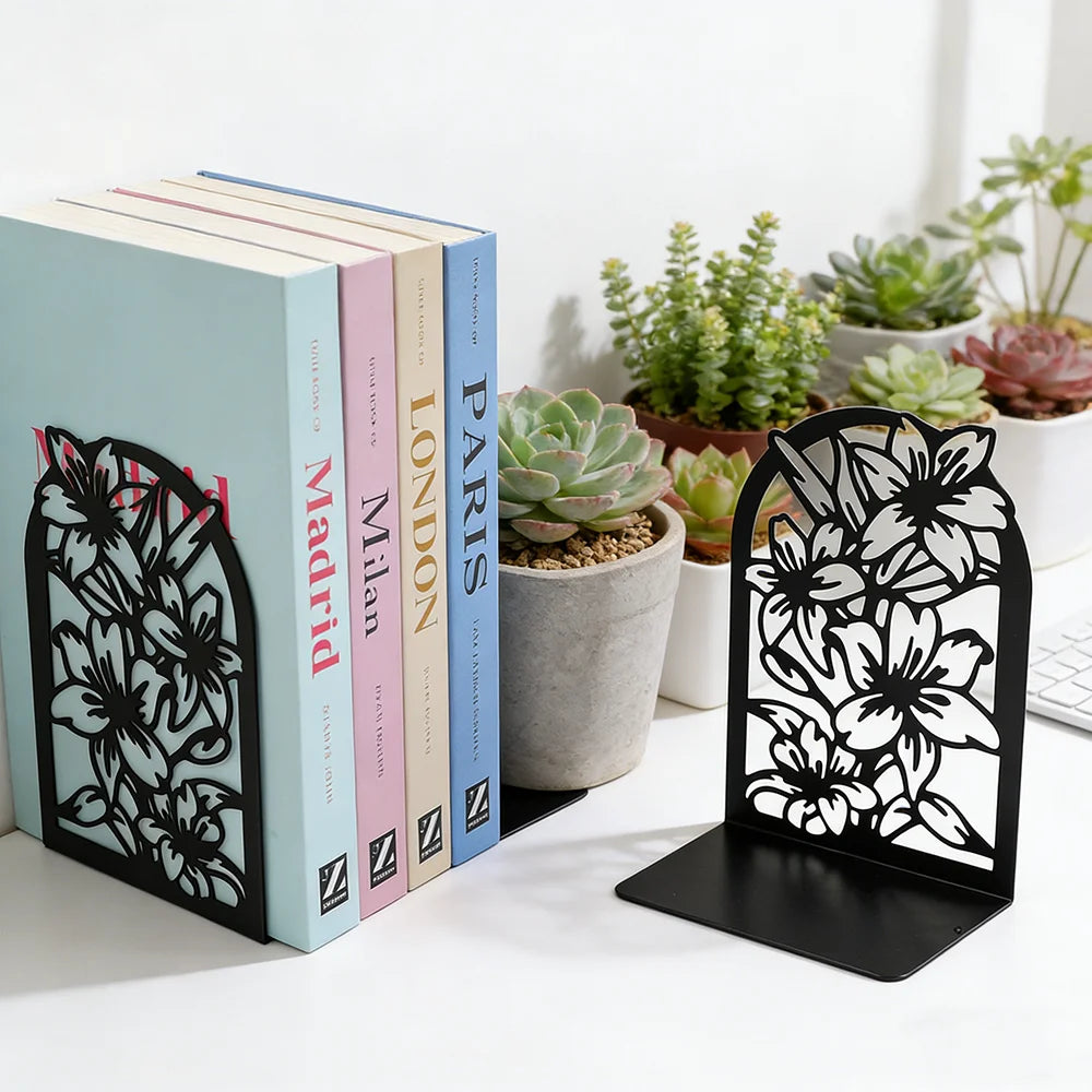 Decorative flower cutout metal bookends supporting pastel-colored books beside potted plants