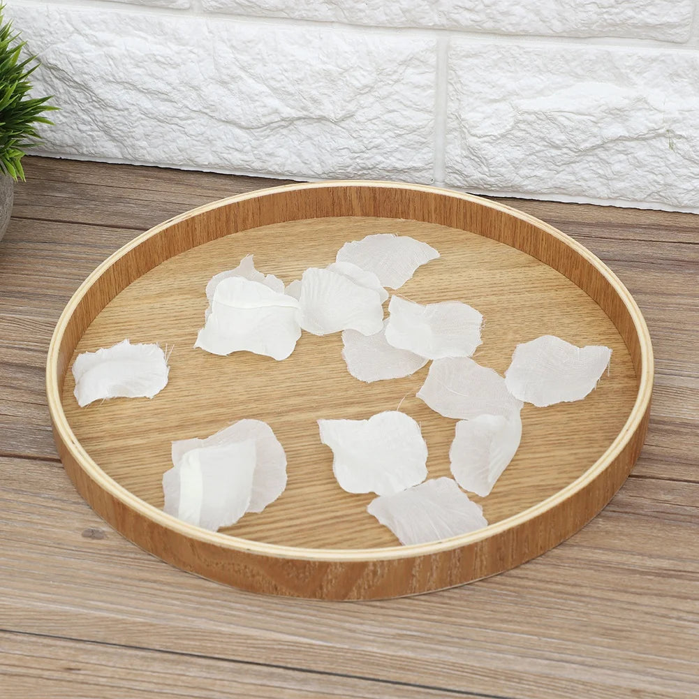 Round wood tray on wood countertop with white decorative petals