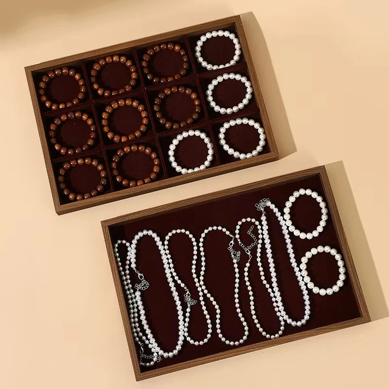 Wooden jewelry display tray with slots for bracelets and another tray with necklace compartments