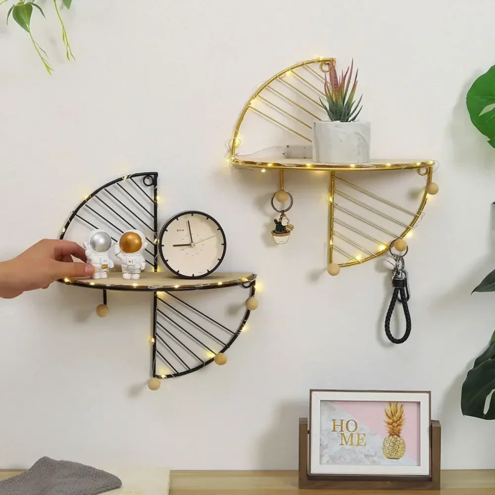 Two semi-circular wall shelves with metal frames in black and gold, styled with small decor, keys, and a plant in a living space.