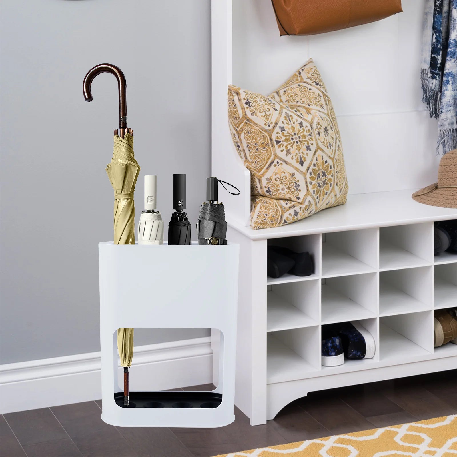 White umbrella stand placed in an entryway, storing four umbrellas