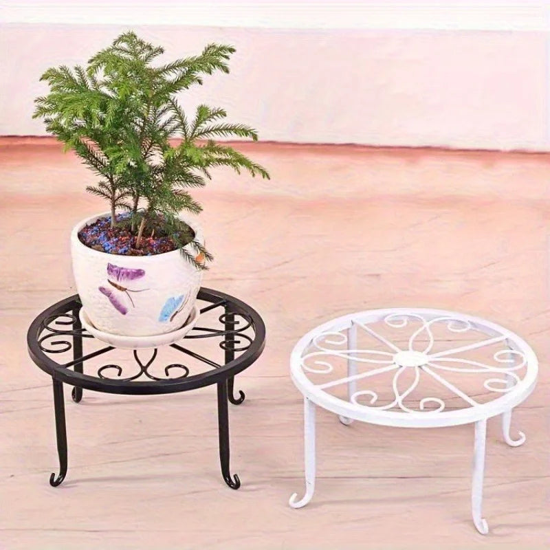 Two metal plant stands in black and white, each holding a potted plant on a floor