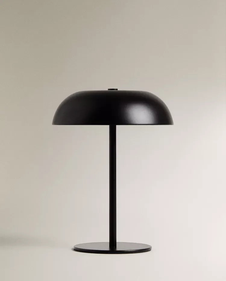 Black cordless table lamp with simple modern design on a neutral backdrop
