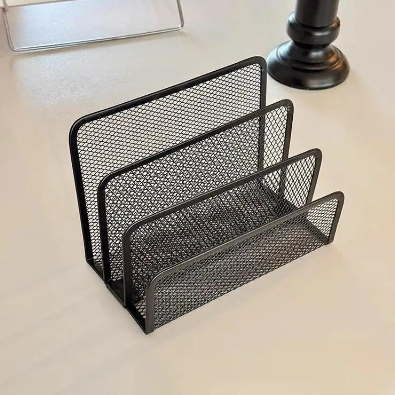Angled view of black mesh mail organizer with three compartments on a tabletop