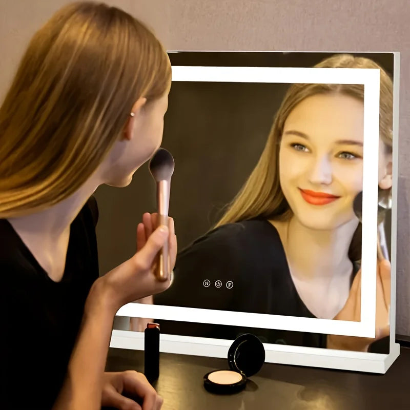 person applying makeup in front of a large lighted vanity mirror on a tabletop