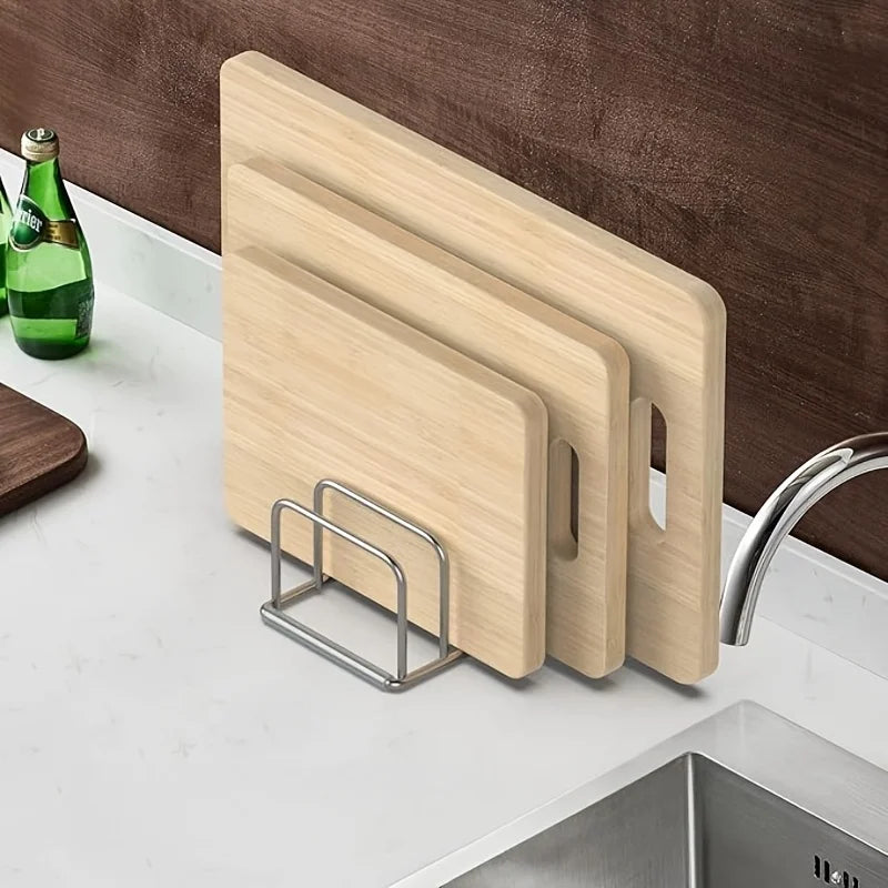 Stainless steel rack holding three cutting boards on a kitchen counter by the sink