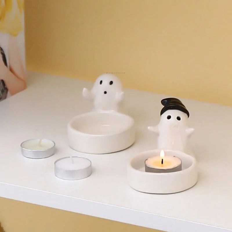 ceramic ghost candle holders on a white shelf with tealight candles