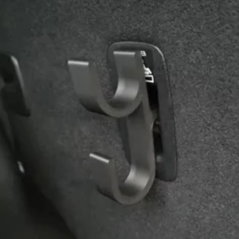 Close-up of a black double-hook umbrella hook mounted inside a car trunk