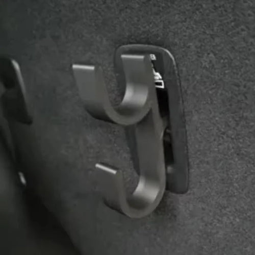 Close-up of a black double-hook umbrella hook mounted inside a car trunk