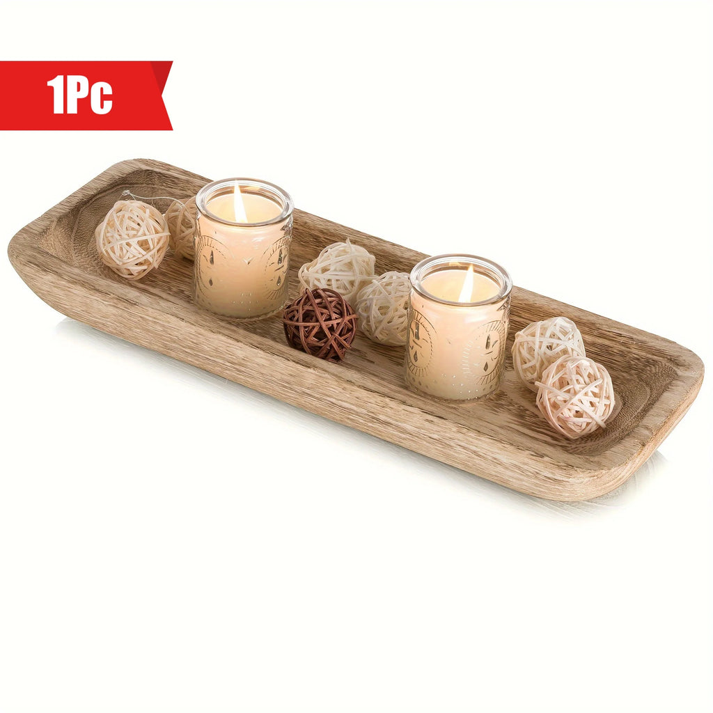 Narrow rectangular wooden tray on a white surface, styled with candles and decorative rattan balls