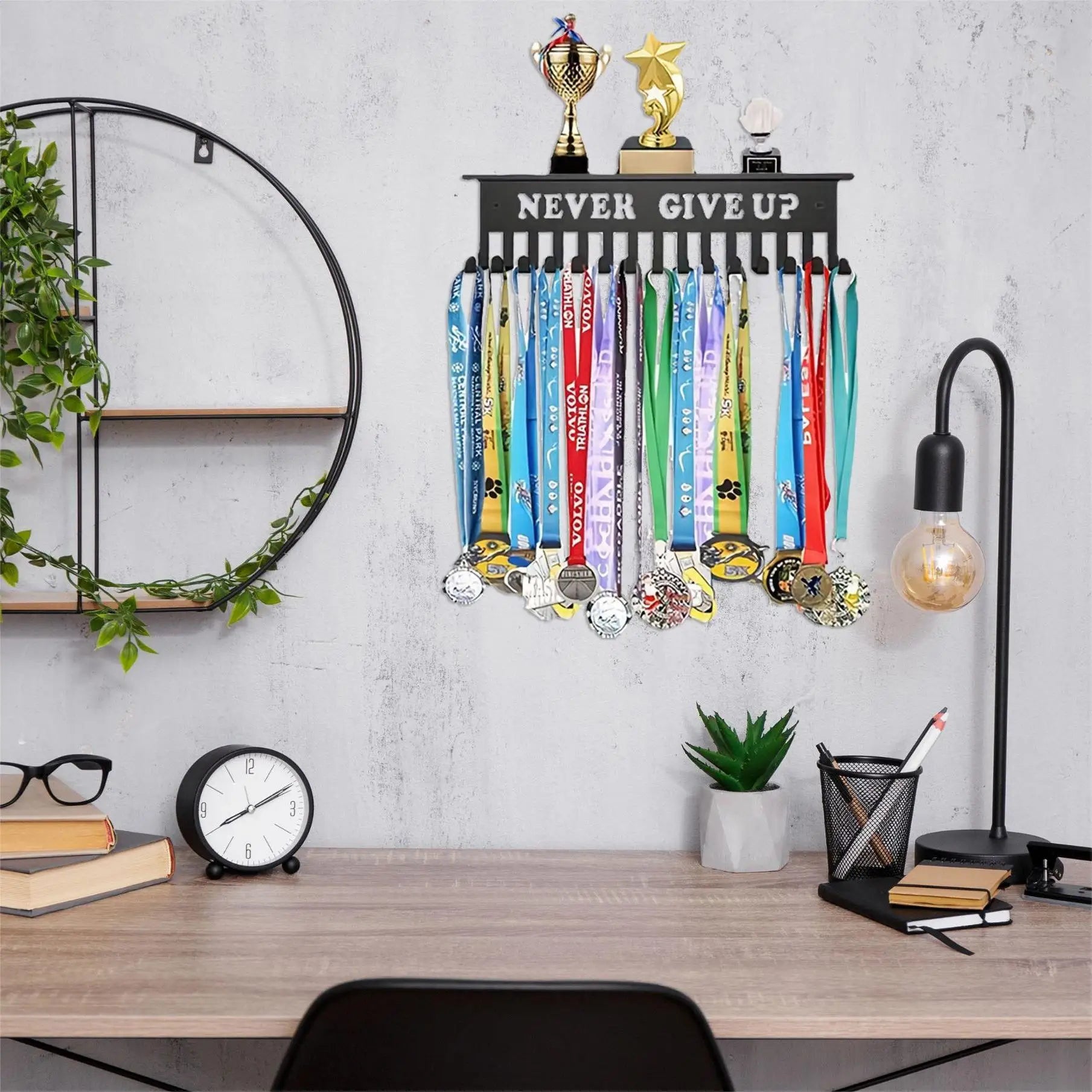 Wall-mounted 'NEVER GIVE UP' medal and trophy rack above a modern home office desk