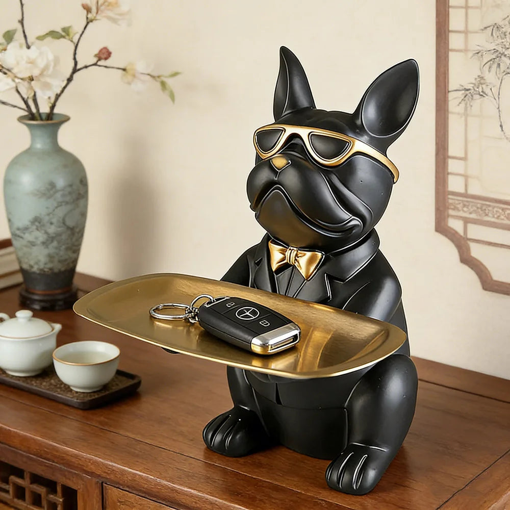 Black resin bulldog figure catchall tray holding keys on a wood entry table