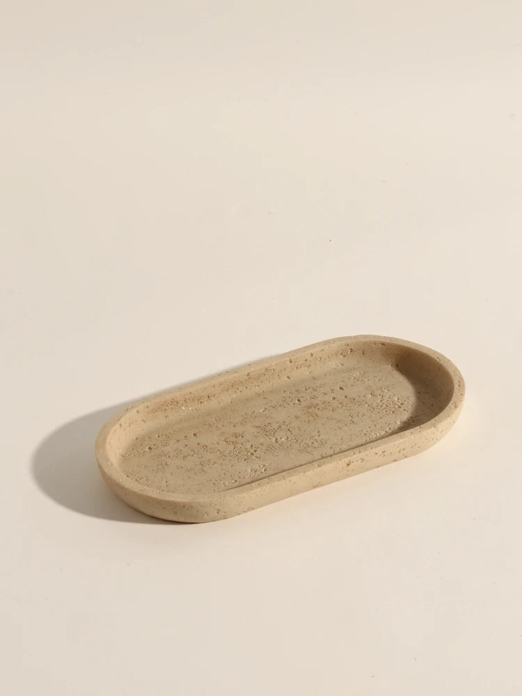 Small beige oval stone bathroom tray on a neutral background