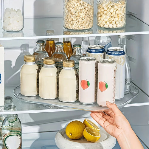 Rectangular turntable organizer in fridge holding various bottles and cans