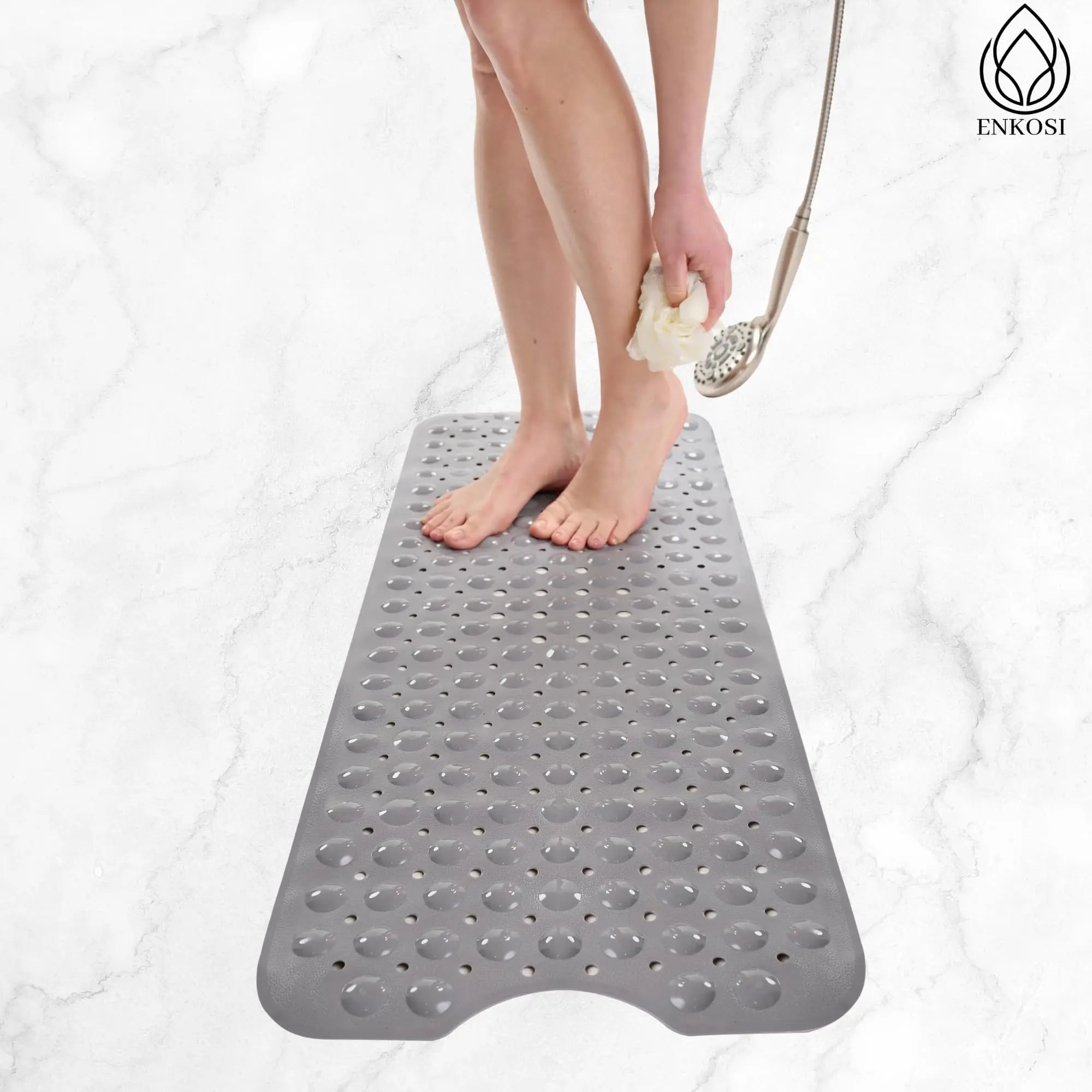 Person standing on a light grey non-slip shower mat, rinsing legs in a bathroom.
