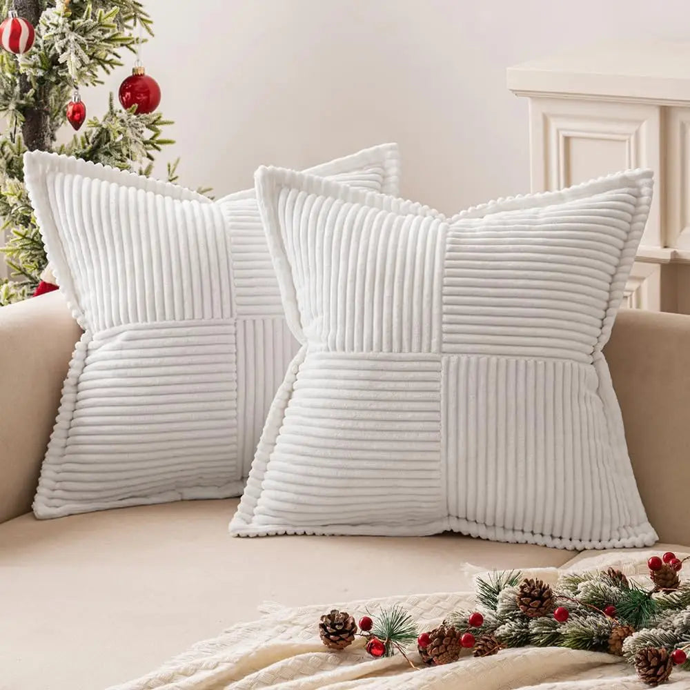 Pair of white corduroy striped pillow covers on a neutral sofa with holiday decorations visible