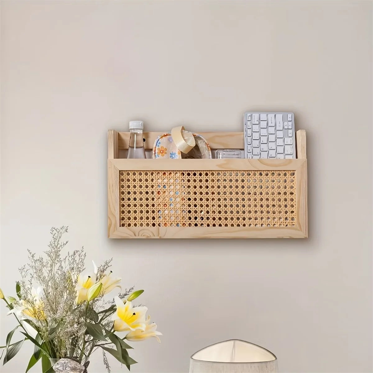 Rectangular wood and rattan wall storage box on a beige wall, filled with various household items