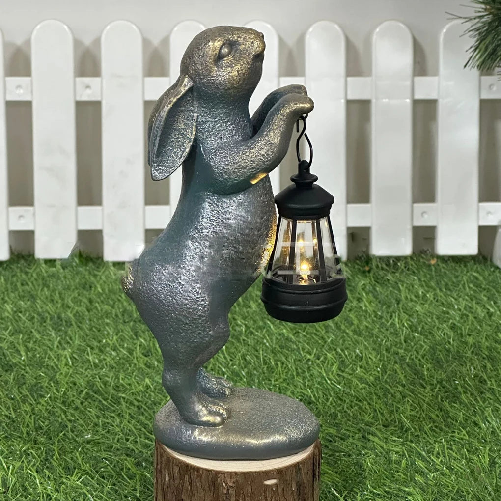 Resin rabbit garden statue holding a solar lantern on artificial grass