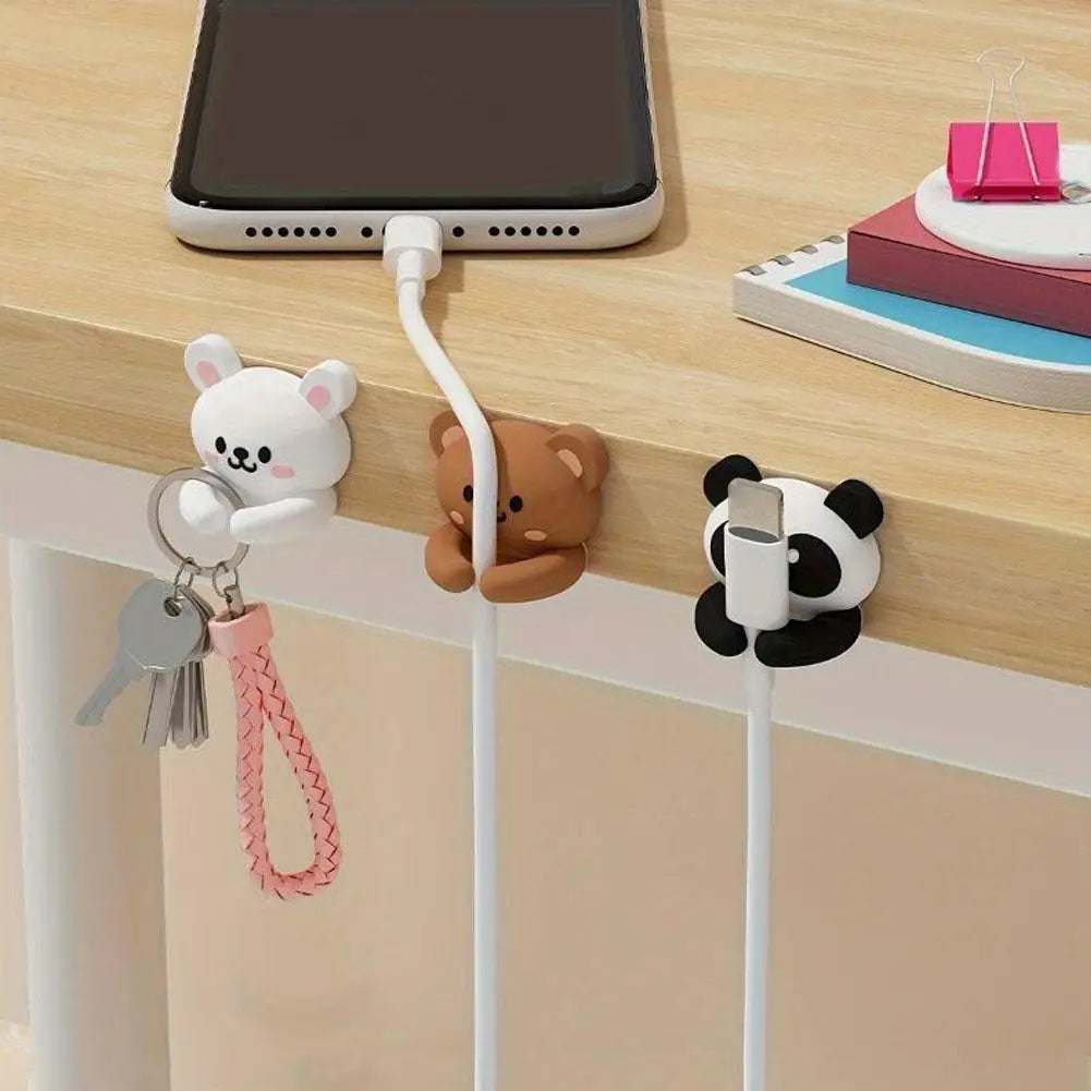Animal cable clips on a desk edge, organizing phone cable and keys