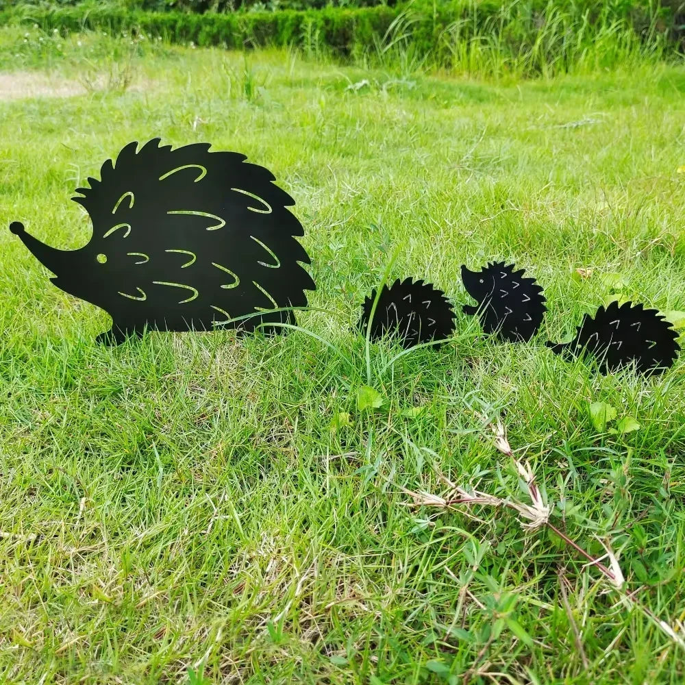 Set of four black metal hedgehog family garden stakes displayed in grass