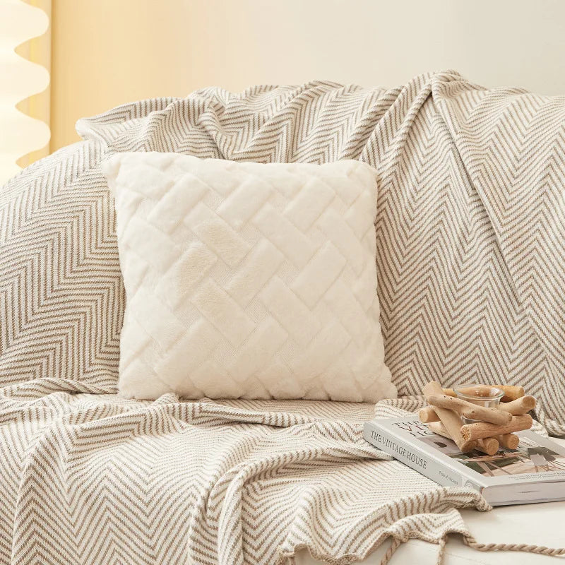 Plush throw pillow cover in white on a patterned blanket and sofa