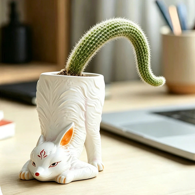 White resin fox-shaped planter with cactus, on a home office desk