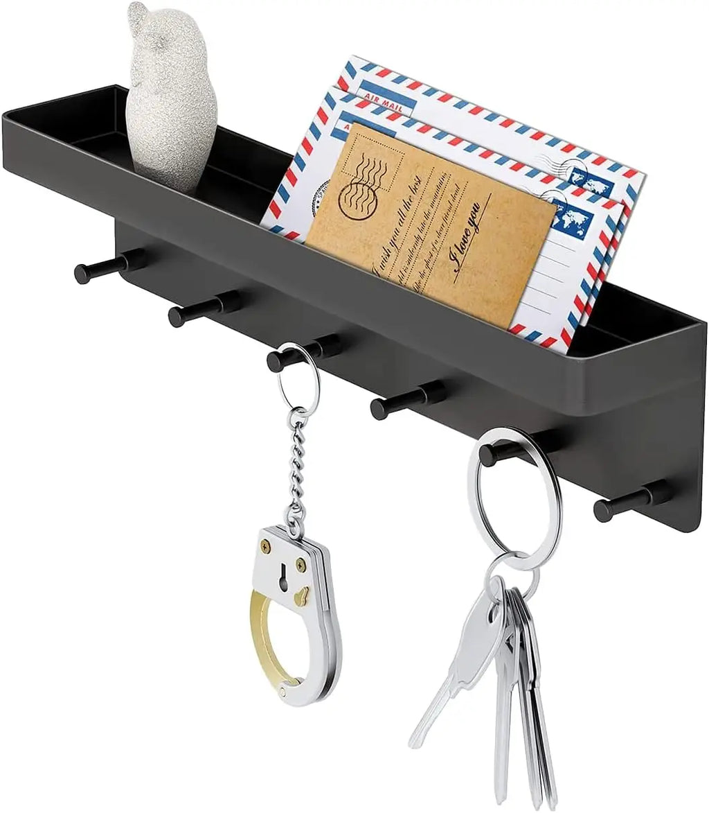 Angled view of a black key holder with tray displaying letters, keychains, and small accessories