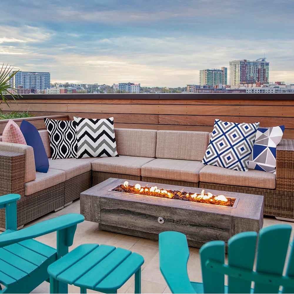 Monochrome and blue geometric outdoor cushion covers arranged on a rooftop patio sectional