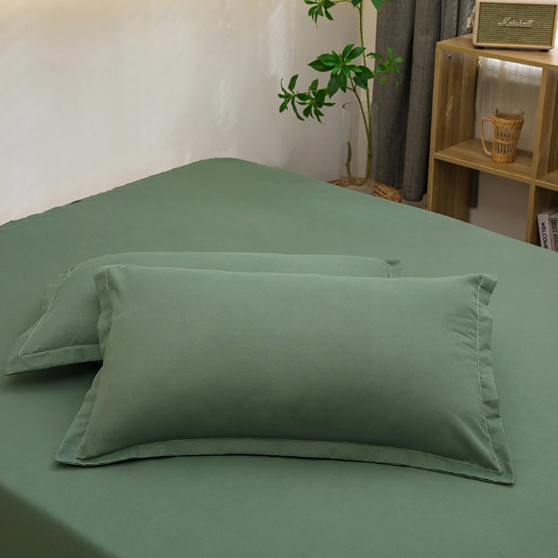 Solid color green pillowcases on a matching bed in a calm bedroom