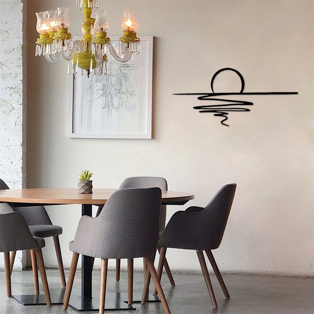 Modern black sunrise metal wall art hanging above a dining table with a chandelier