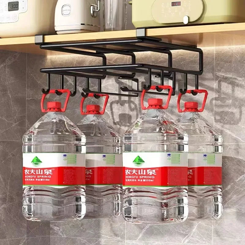 Under cabinet organizer rack with hooks holding large water jugs in a kitchen