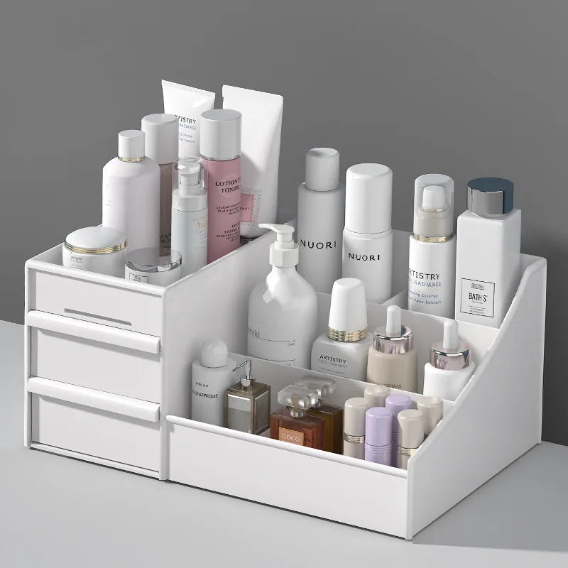 Plastic vanity organizer for makeup and skincare arranged in drawers and compartments against a gray background