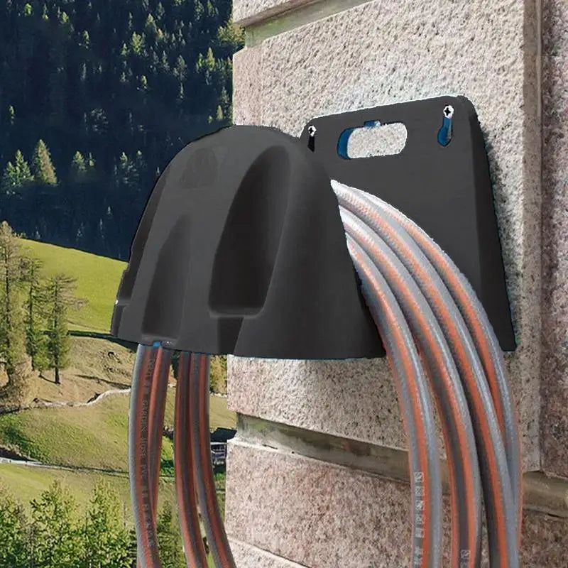 Black wall-mounted garden hose holder installed with hose on exterior wall