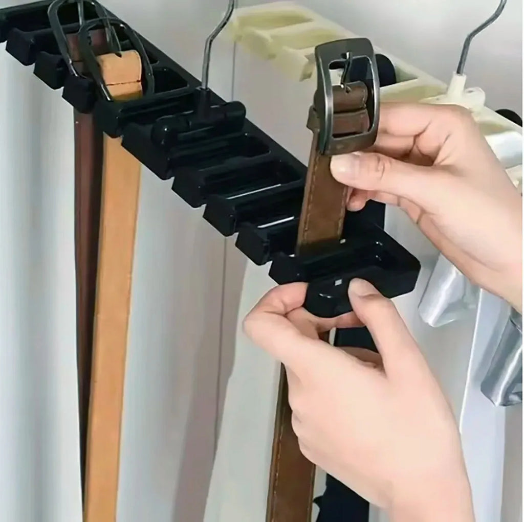 Hands placing a belt into a slot of the black rotating belt and scarf hanger