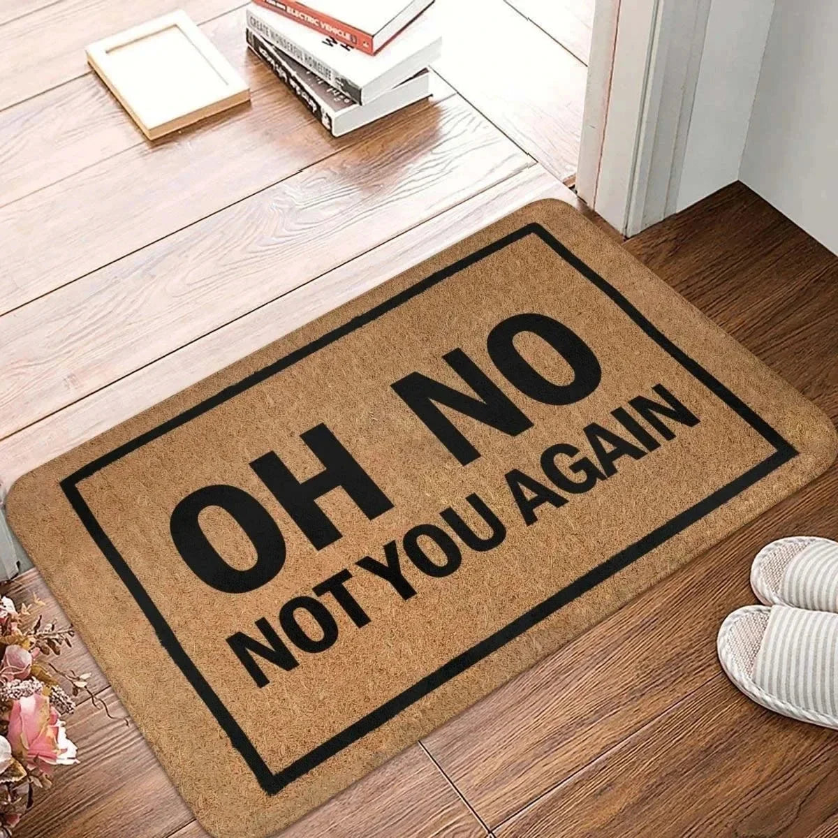 Funny 'Oh No Not You Again' doormat on a wood floor entryway with slippers