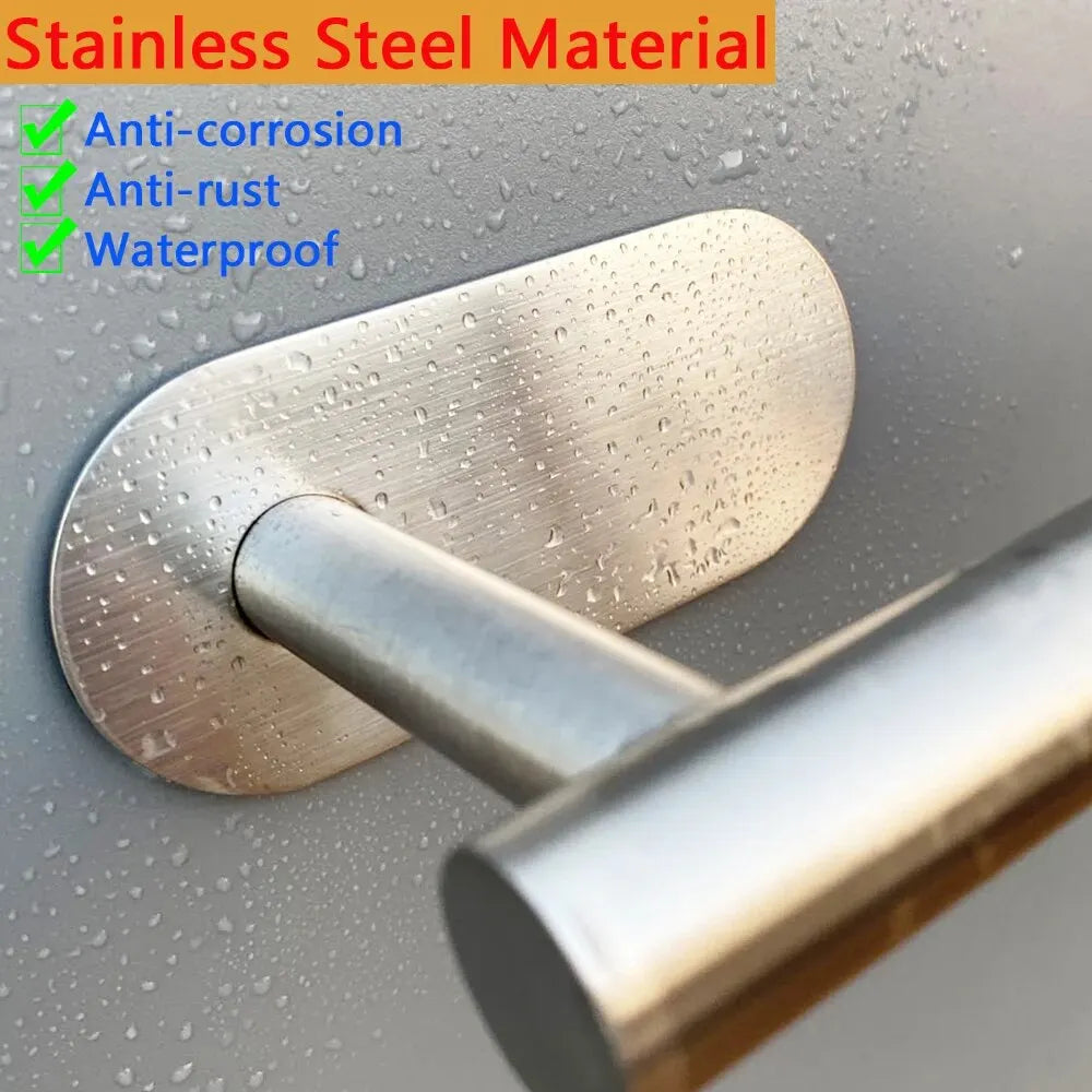 Close-up of silver stainless steel paper towel holder with water droplets on mounting plate
