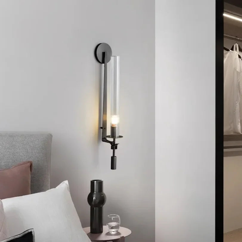 black modern glass wall sconce mounted beside bedroom bed