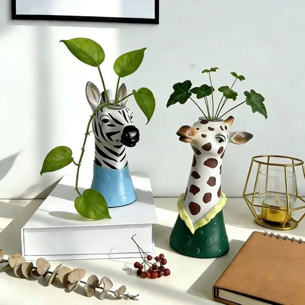 Zebra and giraffe head pottery vases on a tabletop with plants inside