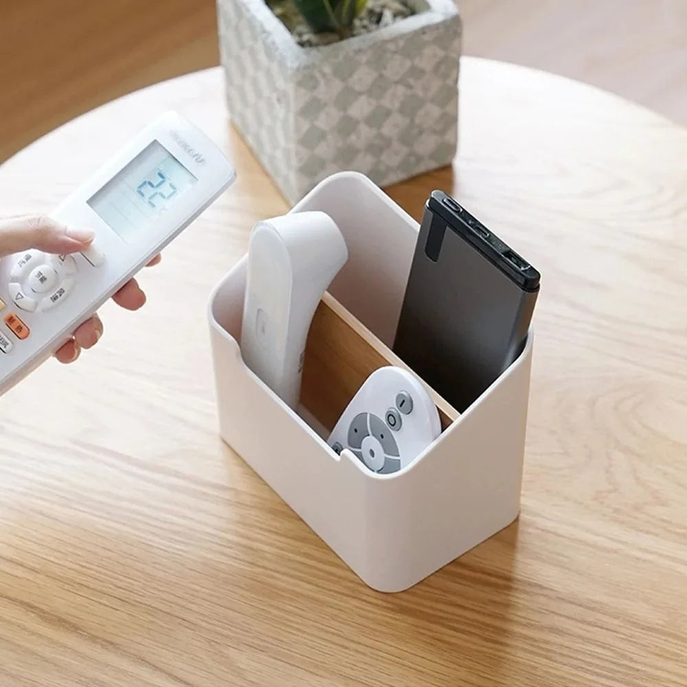 hand reaching for a remote from a white desktop organizer box on a living room table