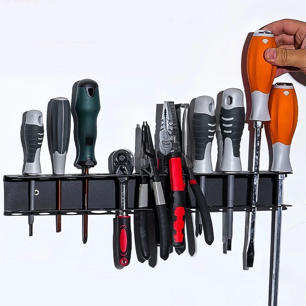 Wall-mounted metal tool rack organizing various screwdrivers, pliers, and hand tools on a white wall, with a hand placing a screwdriver in the rack.
