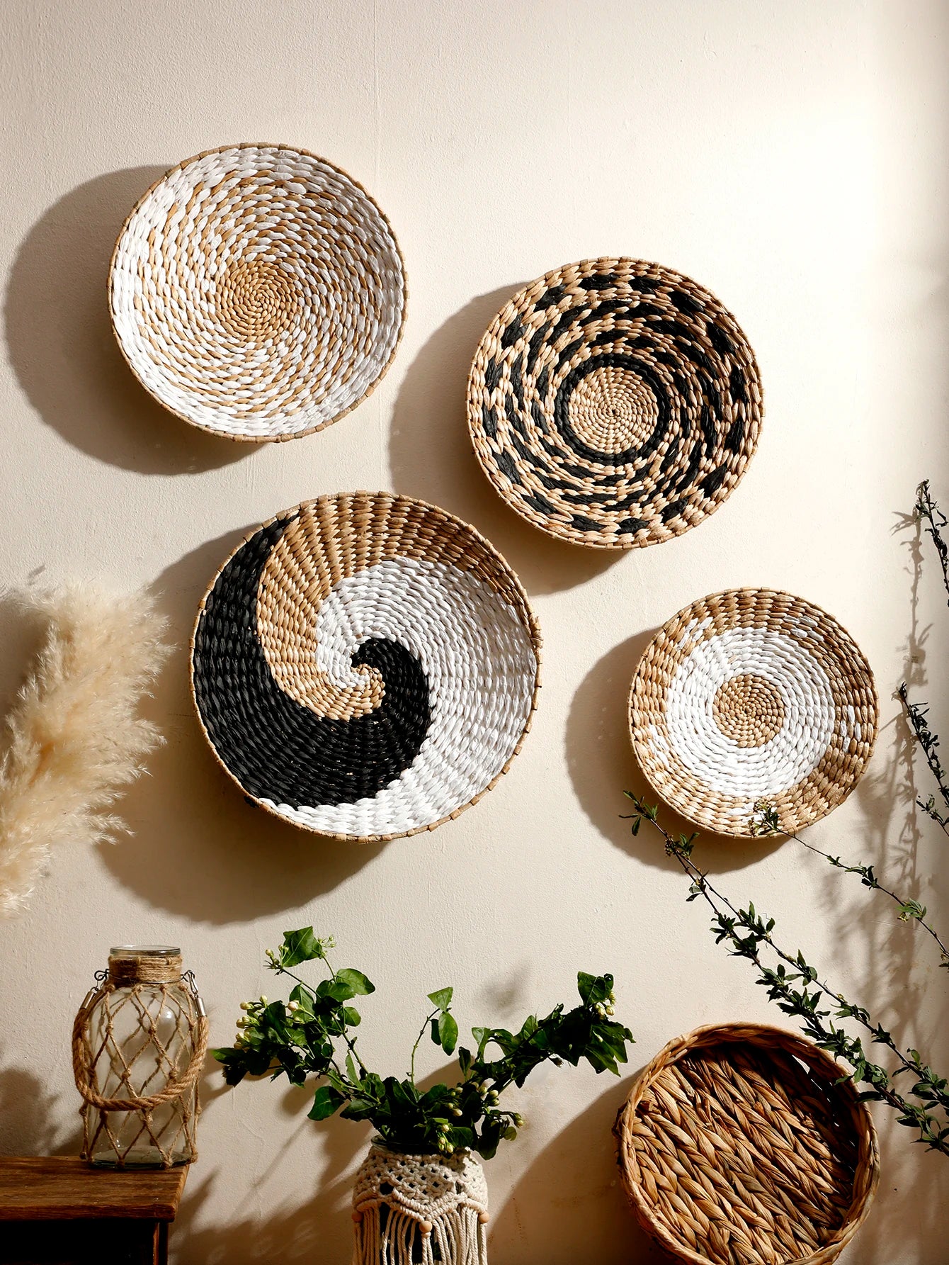Assorted woven seagrass baskets with natural and black patterns arranged as wall decor